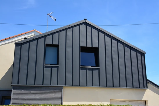 Maison contemporaine à deux étages avec terrasse couverte et jardin paysager au crépuscule