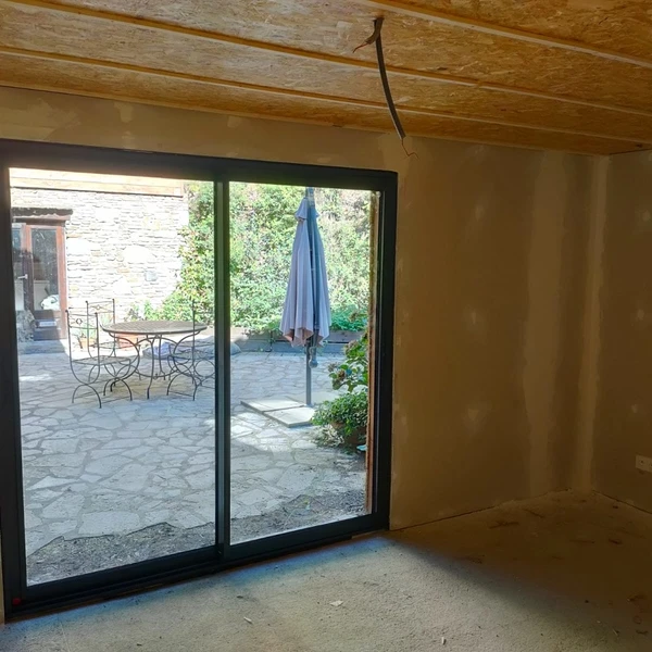 Espace de vie moderne avec verrière et babyfoot dans extension contemporaine