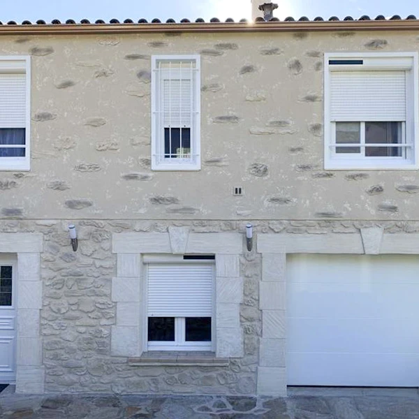 Extérieur résidentiel avec maison blanche à toit de tuiles rouges méditerranéennes, pergola blanche moderne, terrasse carrelée, clôture métallique grise, végétation arbustive
