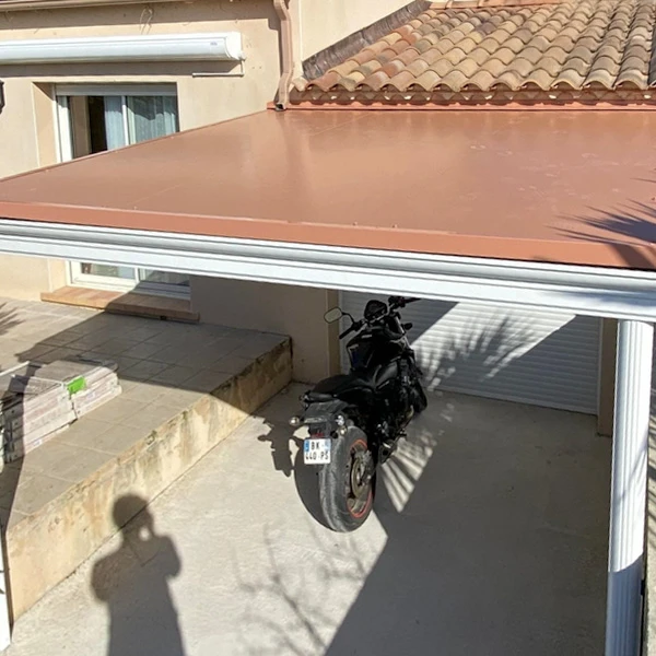 Piscine extérieure résidentielle équipée d'un abri télescopique bas en aluminium et polycarbonate, sur terrasse carrelée