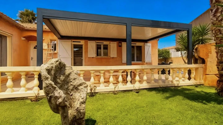 Maison contemporaine en bois avec grande verrière exposée plein sud, balcon à garde-corps métalliques, terrain enneigé avec végétation d'hiver