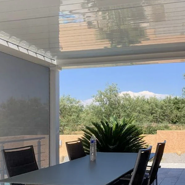 Trois ouvriers en uniformes noirs travaillent sous une pergola bioclimatique avec lames orientables