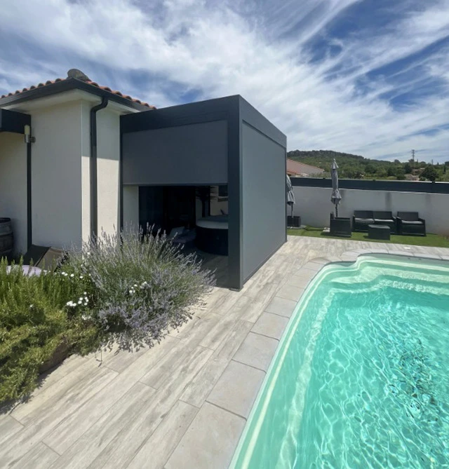 Trois ouvriers en uniformes noirs travaillent sous une pergola bioclimatique avec lames orientables