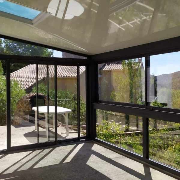 Extérieur d'un bâtiment en bois avec grande baie vitrée à cadre métallique bleu-gris